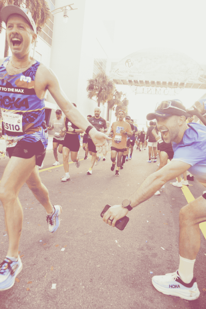 A photo of someone cheering as another person runs past them at the Miami marathon